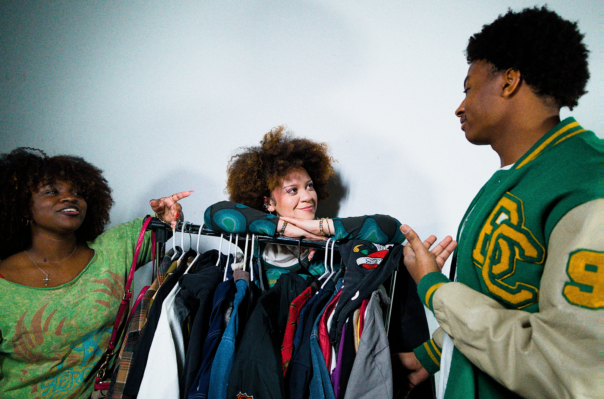 Friends gathered around a thrift clothing rack